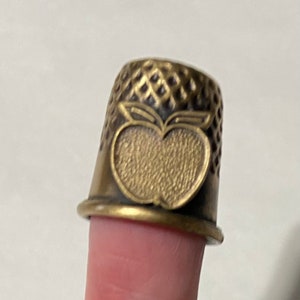 BRASS THIMBLE WITH AN ANGEL DESIGN AFFIXED 