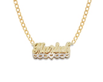 May include: Gold chain necklace with a two-tone nameplate pendant that says "Mariah" with a heart in the center.