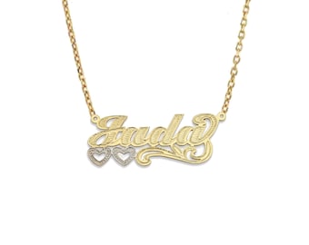 May include: A gold necklace with a cursive nameplate that reads "Jada" with three small hearts below the name.
