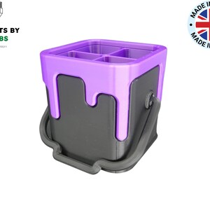 May include: A purple and black paint can shaped desktop organiser with four compartments.