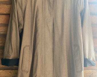 May include: A brown and white gingham patterned coat with a black collar and cuffs. The coat has a single button closure and two pockets.