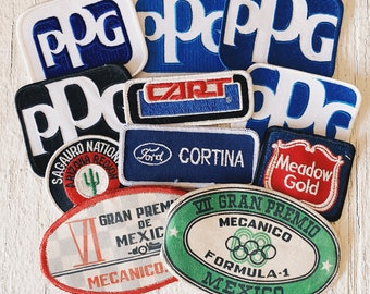May include: A collection of vintage embroidered patches featuring various logos and designs, including "PPC", "CART", "Ford Cortina", "Saguaro National", "Meadow Gold", and two patches for the "VII Gran Premio de Mexico" race.