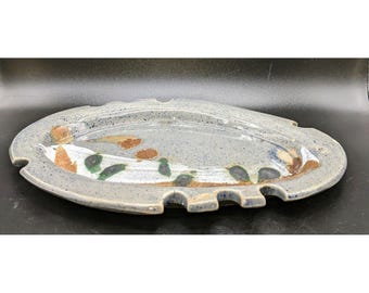 May include: A blue and white ceramic serving tray with a scalloped edge and brown and green painted designs.