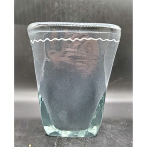 May include: A clear glass vase with a wavy white rim. The vase has a wide mouth and a narrow base.
