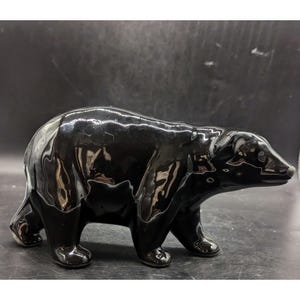May include: A black ceramic bear figurine. The bear is standing on all fours and has a glossy finish.