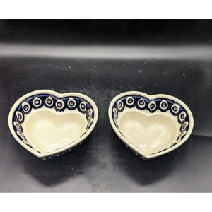 May include: Two heart-shaped ceramic bowls with a blue and white eye pattern. The bowls are made in the traditional Polish pottery style.