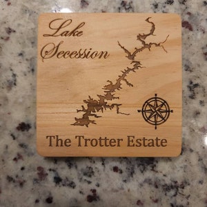 Pu&ograve; includere: Un sottobicchiere in legno con una mappa del lago Secession e il testo "The Trotter Estate".