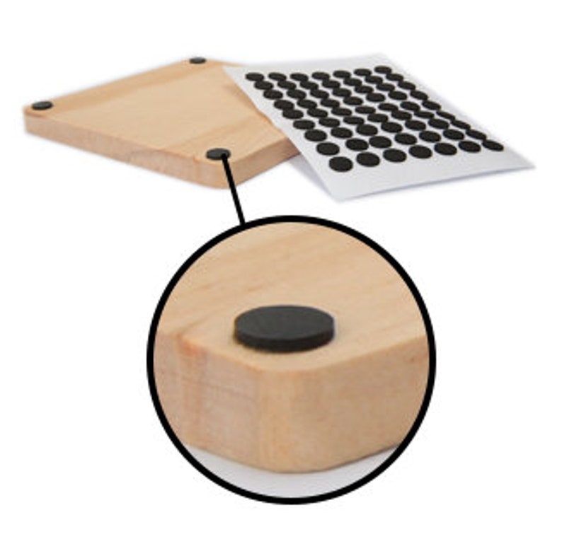 Pu&ograve; includere: Un sottobicchiere quadrato in legno con quattro piedini in gomma nera sul fondo. I piedini sono attaccati al fondo del sottobicchiere.