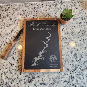 May include: A wooden chopping board with a black slate insert. The slate is engraved with the text "Hall Family Lake House" and a map of Lake Secession in South Carolina.