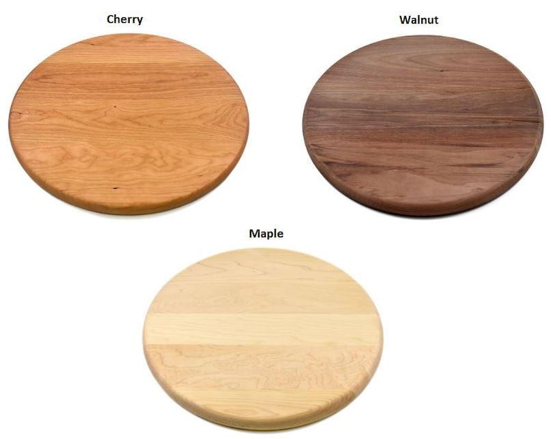 May include: Three round wooden cutting boards in cherry, walnut, and maple. The cherry board is a light reddish-brown, the walnut board is dark brown, and the maple board is a light tan color. Each board has a smooth surface.