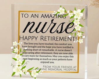 May include: A clear acrylic block with gold edging, featuring the words "TO AN AMAZING nurse HAPPY RETIREMENT!" in black script. White flowers and green leaves adorn the edges. The text conveys a message of gratitude for a nurse's service.