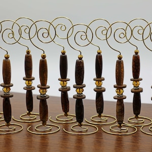 Puede incluir: Diez portafotos de metal dorado con diseño en espiral. Cada portafotos tiene una base de piedra de ágata marrón y negra con detalles dorados.