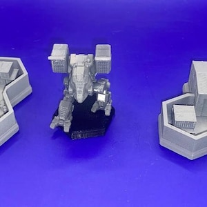 May include: Three gray 3D printed miniature buildings with a silver robot in the center. The buildings have a hexagonal base and are designed to be used as terrain for tabletop games.