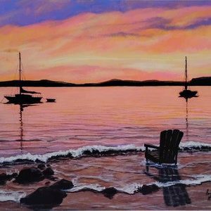 May include: A painting of a sunset over a calm body of water with two sailboats in the distance and a wooden chair sitting in the shallows.