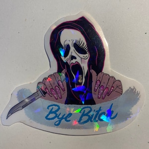 May include: A holographic sticker featuring a cartoon character wearing a white mask with a scream expression, holding a knife and with the text "Bye Bitch" in blue.