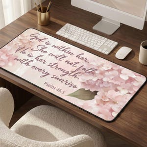 May include: A rectangular desk mat featuring a floral design in shades of pink and white, with the text "God is within her. She will not fall. He is her strength with every sunrise. Psalm 46:5".