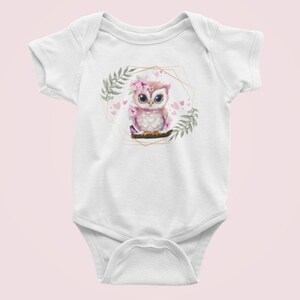 May include: White baby onesie with a pink owl wearing a flower crown and surrounded by pink hearts and greenery in a gold geometric frame.