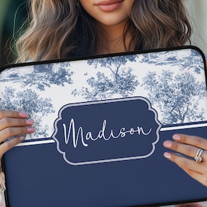 May include: Laptop case with a blue and white toile pattern featuring trees and a landscape design. The case has a navy blue bottom section with the name "Madison" in white script within a decorative frame.