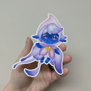 May include: A sticker featuring a whimsical blue creature with a flower-like design. The creature has a blue face, large eyes, and a pink and white head covering. Its wings and body are shades of purple with a starry pattern.