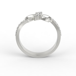 May include: A silver ring with a knot design and small diamonds set in the knot. The ring is on a white background.