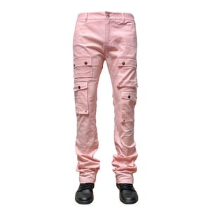May include: Light pink cargo pants with multiple pockets and a button closure. The pants have a straight leg design and are shown with black shoes. The fabric appears to be a soft, textured material.