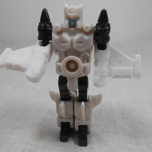 May include: A white and black action figure of a robot with wings. The robot has a white body with black accents on the shoulders and legs. The robot's head is white with a blue face. The figure is standing with its arms outstretched.