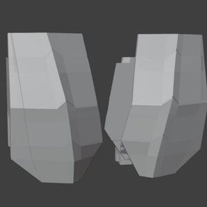 Puede incluir: Dos objetos geométricos tridimensionales de color gris claro con múltiples facetas planas y angulares. Cada objeto presenta una forma poliédrica compleja e irregular con bordes afilados y planos distintos, presentados como un modelo 3D.