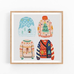 Puede incluir: Una impresión enmarcada con cuatro diseños de suéteres de punto de cruz coloridos. Los suéteres son en tonos de azul, rosa y rojo, cada uno con patrones únicos con temas navideños, incluyendo un árbol de Navidad y estrellas. La obra de arte se muestra sobre un fondo gris claro.