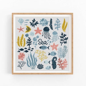 May include: A cross-stitch pattern featuring a variety of sea life, including starfish, jellyfish, seaweed, and fish. The pattern is framed in a light wood frame and includes the word "Sea" in the center.