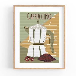 Peut inclure: Une œuvre d'art au point de croix encadrée représentant une cafetière à cappuccino blanche avec une poignée marron et un tas de grains de café. Le mot "CAPPUCCINO" est brodé en marron au-dessus de la cafetière, sur un fond vert et beige.