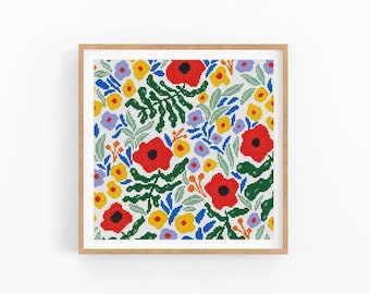 Könnte beinhalten: Ein gerahmtes Kreuzstichmuster mit einem farbenfrohen Blumenmuster. Es zeigt rote Mohnblumen, gelbe und lila Blüten und grüne Blätter auf weißem Grund. Das Kunstwerk ist in einem hellbraunen Holzrahmen eingefasst, ideal für die Wanddekoration.