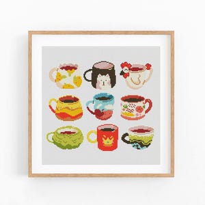May include: A framed print featuring a grid of nine colorful mugs, each with unique designs. The mugs are filled with a warm beverage and decorated with patterns, animals, and floral motifs. The artwork is a cross-stitch style.