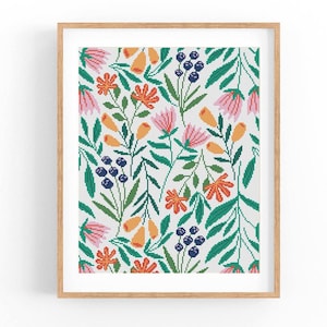 May include: A framed cross-stitch pattern featuring a colorful floral design with pink, orange, yellow, green, and blue flowers and leaves on a white background.
