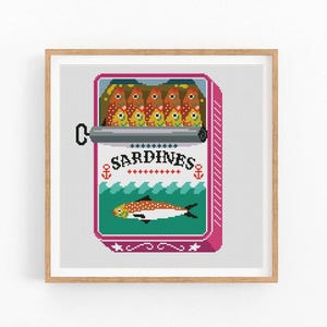 May include: A cross-stitch pattern of a vintage can of sardines. The can is red and white with a blue and green illustration of a sardine swimming in the ocean. The text "SARDINES" is printed on the can.