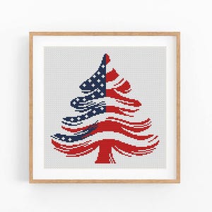 May include: A framed cross-stitch design featuring a stylized Christmas tree in red, white, and blue, resembling the American flag. The tree's branches are formed by the flag's stripes and stars. The artwork is set against a white background.