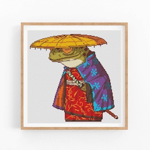 May include: A green frog wearing a purple and blue robe with a red and gold floral pattern. The frog is wearing a yellow conical hat and holding a stick.
