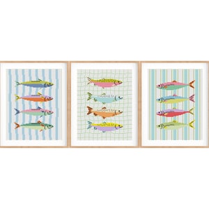 Puede incluir: Tres impresiones artísticas enmarcadas con peces pixelados de colores. Cada impresión tiene un patrón de fondo diferente: rayas azules y blancas, una cuadrícula verde y rayas verdes y blancas. Los peces son de varios colores, incluyendo rosa, amarillo y naranja.