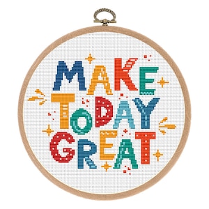 May include: A round embroidery hoop with white Aida cloth and a colorful cross-stitch design that reads "MAKE TODAY GREAT".