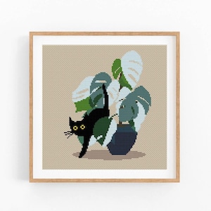 May include: Cross stitch pattern featuring a black cat with yellow eyes peeking out from behind a potted plant with large green and white leaves.