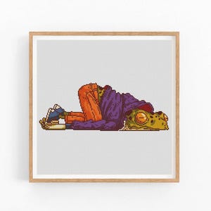 May include: A pixel art cross stitch pattern of a frog wearing a purple hooded jacket and orange pants, lying on its side.
