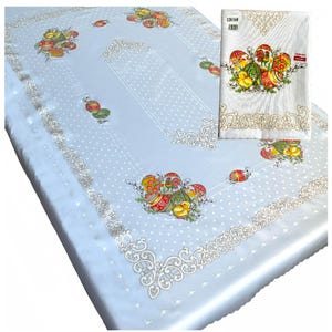 May include: A light blue tablecloth with a white polka dot pattern and a white embroidered border. The tablecloth features a design of colorful Easter eggs and chicks. The tablecloth is 120x160 cm.