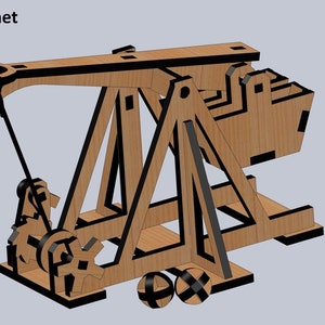 Puede incluir: Un modelo de catapulta de madera con detalles negros. La catapulta tiene un brazo largo con una honda y un contrapeso. La base de la catapulta est&aacute; sobre ruedas.