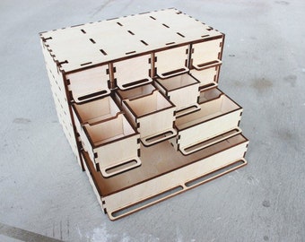 May include: A wooden organizer with multiple drawers. The organizer is made of light wood and has a natural finish. The drawers are all different sizes and are arranged in a staggered pattern.