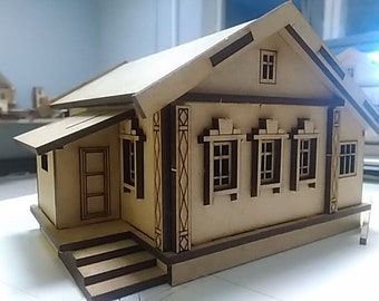 May include: A wooden model of a house with a brown roof, white walls, and brown trim. The house has three windows with brown frames and a small porch with steps.