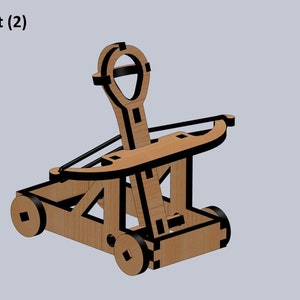Puede incluir: Un juguete de catapulta de madera con un acabado marr&oacute;n y detalles negros. La catapulta tiene un brazo de palanca, una honda y dos ruedas. El juguete est&aacute; dise&ntilde;ado para lanzar objetos peque&ntilde;os.