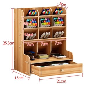 May include: A wooden desk organizer with a drawer and multiple compartments for pens, pencils, and other office supplies. The organizer measures 9 inches tall, 7.5 inches wide, and 10 inches deep.