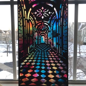 May include: A black paper cut-out of a hallway with a stained glass window design. The hallway has a checkered floor and the stained glass is in shades of blue, green, yellow, orange, and pink.