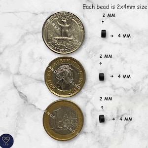 May include: Image showing black beads next to a US quarter, a British pound coin, and a Euro coin. The text indicates each bead is 2x4mm in size. The beads are small, cylindrical, and black, with arrows pointing to their dimensions.