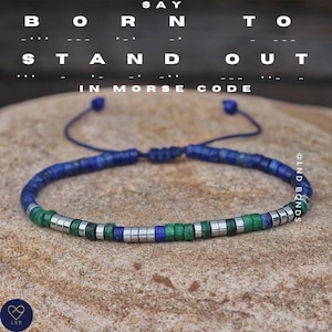 Op de afbeelding: Een blauwe en groene kralen armband met zilveren kralen. De armband is gemaakt met lapis lazuli, aventurijn en hematiet kralen. De armband is vastgemaakt met een blauw koord en heeft een schuifknoop.