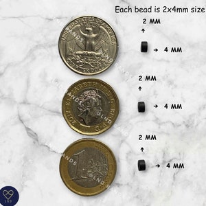 May include: Image showing black beads next to a US quarter, a British pound coin, and a Euro coin. The text indicates each bead is 2x4mm in size. The beads are cylindrical and appear to be made of a solid, dark material.